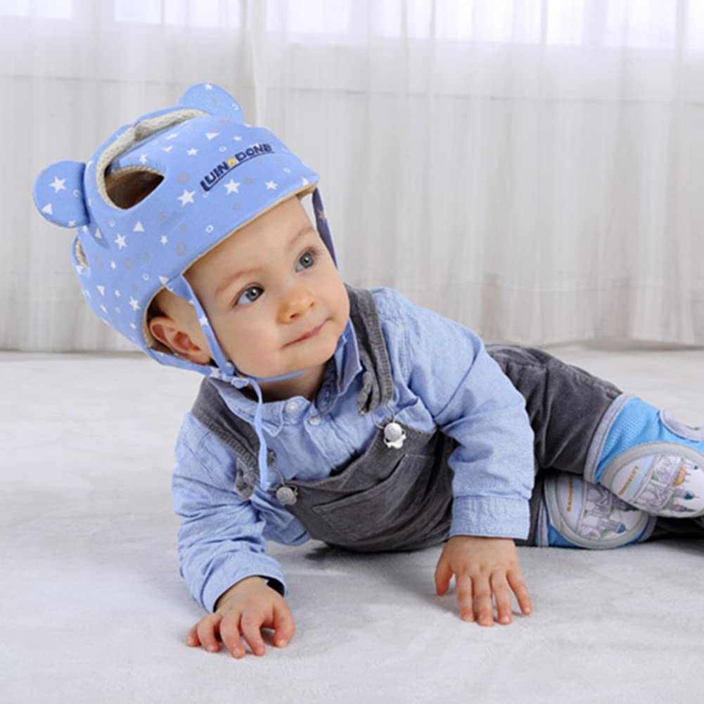 Baby wearing a blue helmet with star pattern on a light background