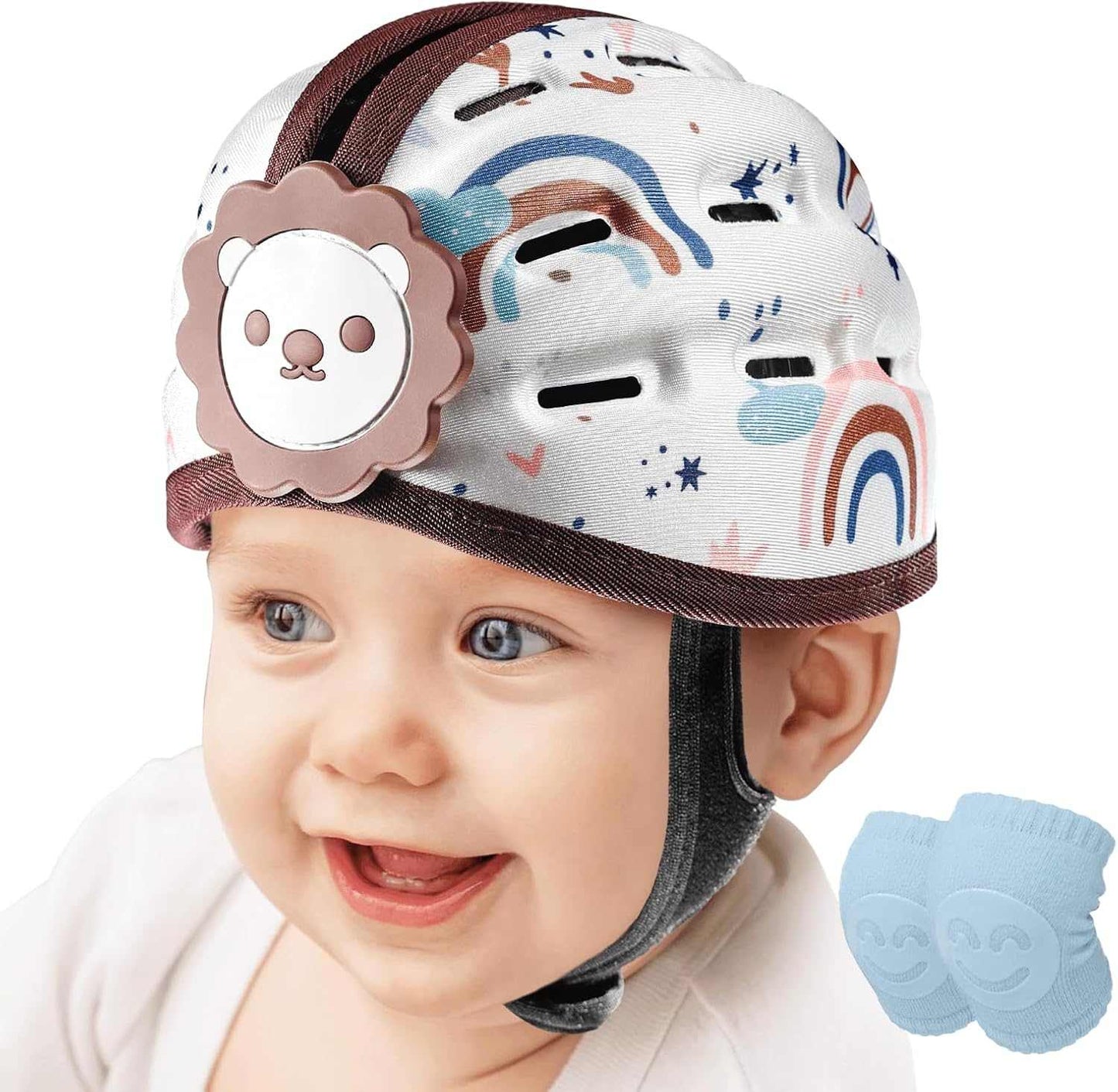Baby wearing a colorful helmet with a lion design, smiling on a white background.