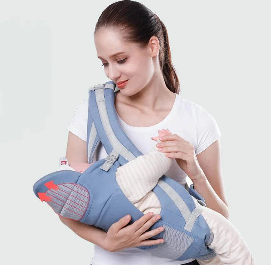 Woman holding a baby in a blue baby carrier against a white background