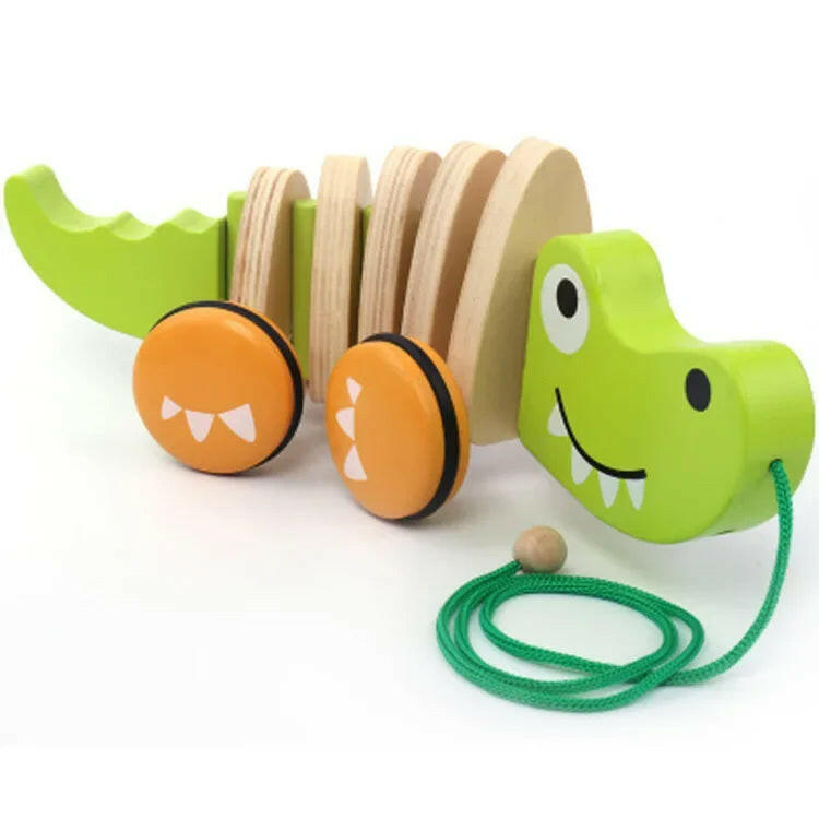 Wooden toy with a green dinosaur head and orange wheels on a white background