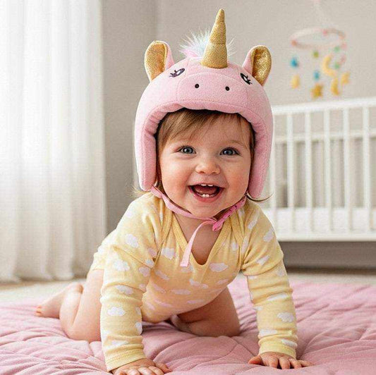 A happy baby girl wearing a pink Unicorn Baby Safety Helmet, smiling while crawling on a soft mat in a bright nursery.