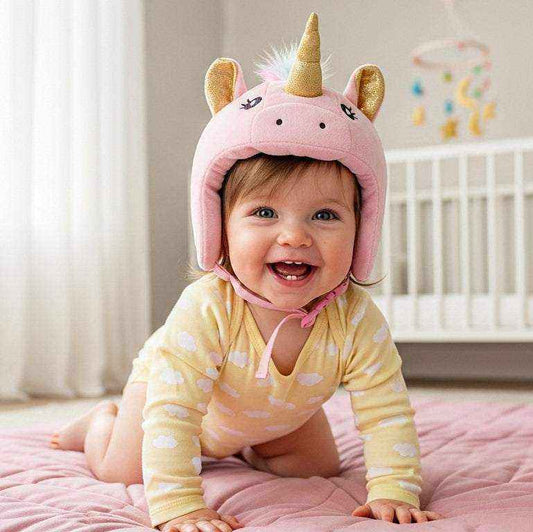 A happy baby girl wearing a pink Unicorn Baby Safety Helmet, smiling while crawling on a soft mat in a bright nursery.