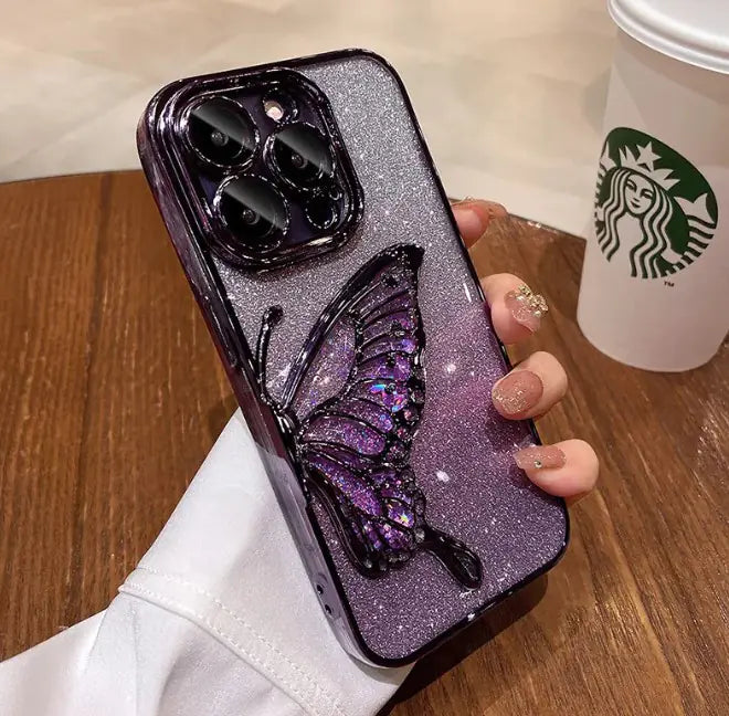 Phone case with butterfly design held by a hand, Starbucks cup in the background