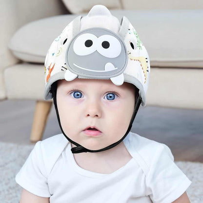Baby wearing grey dinosaur themed baby safety helmet for toddler protection during crawling and walking