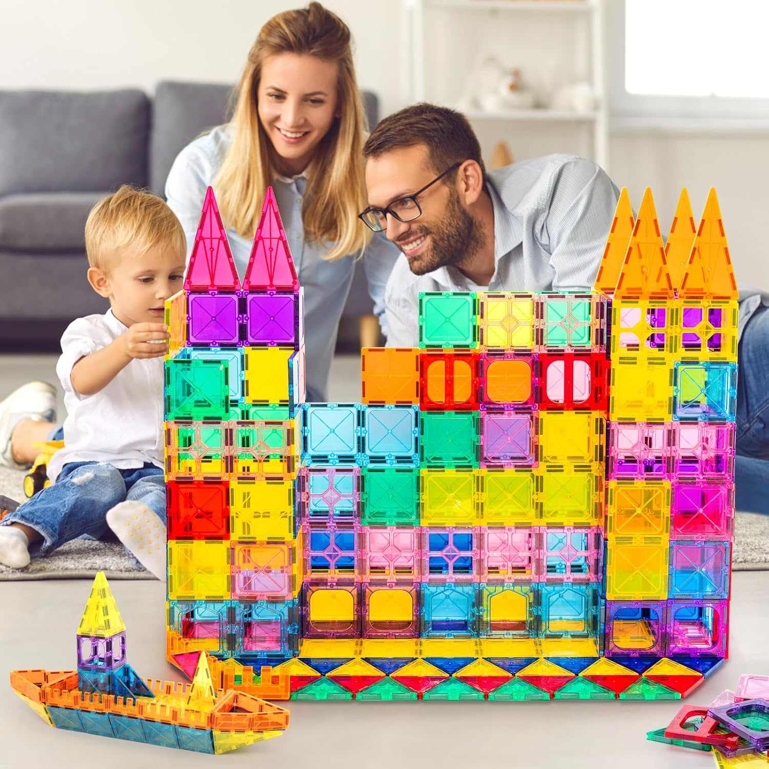 Family playing with colorful magnetic building blocks in a living room.