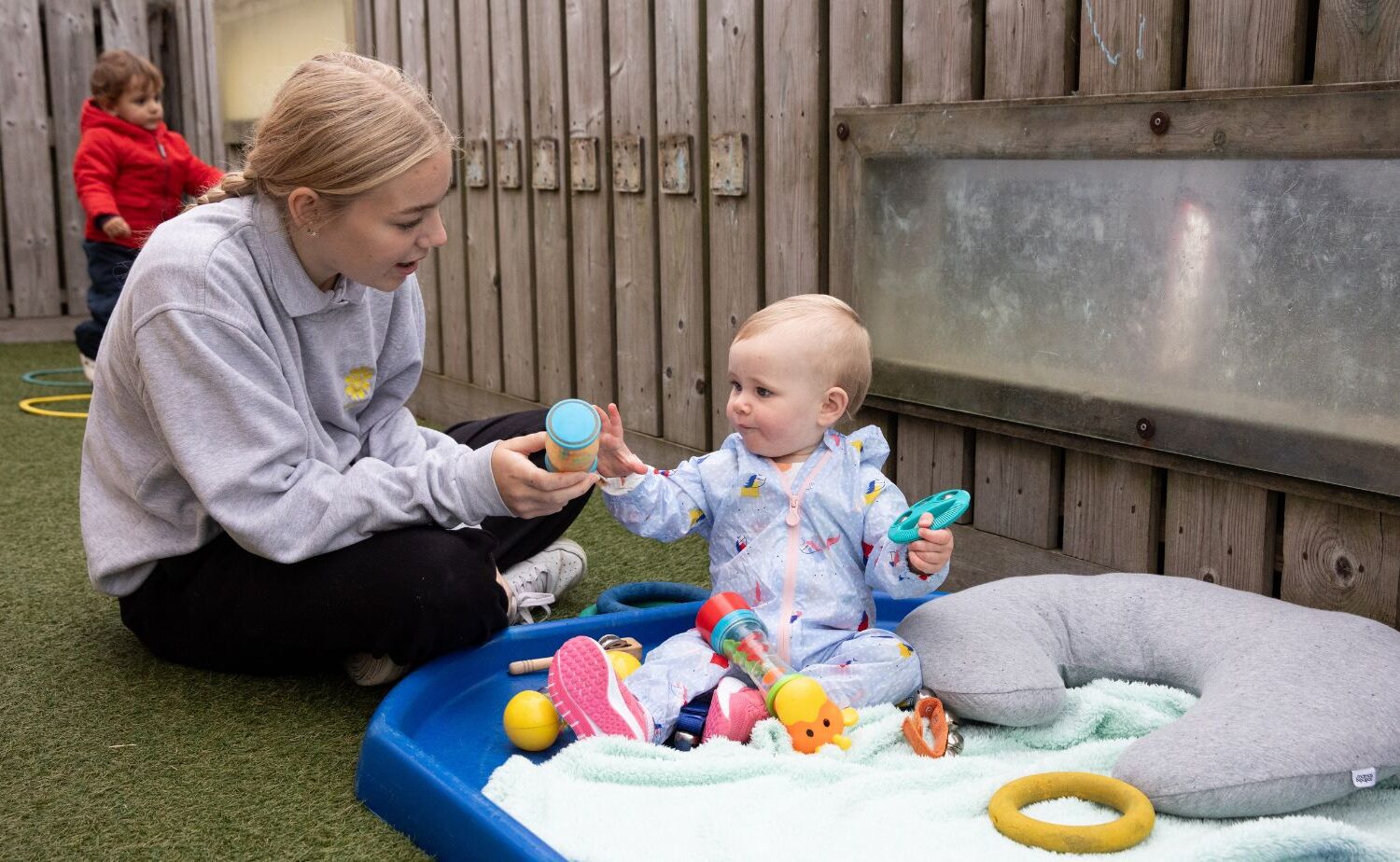 Woman playing with a baby in an outdoor play area