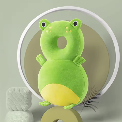 Green frog-shaped pillow on a neutral background