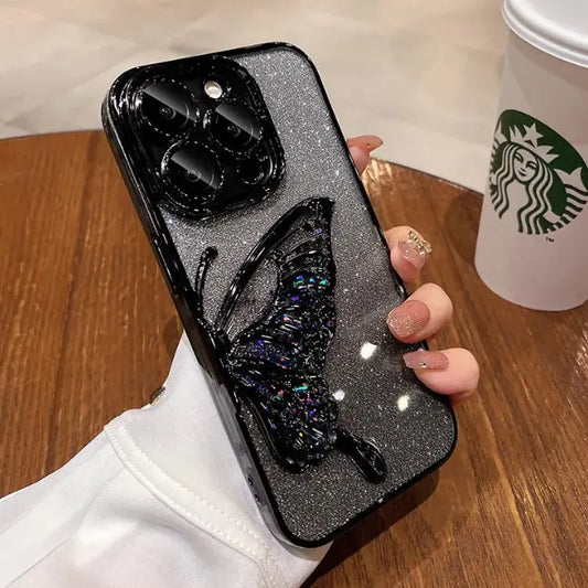 Phone case with butterfly design held by a hand, Starbucks cup in the background